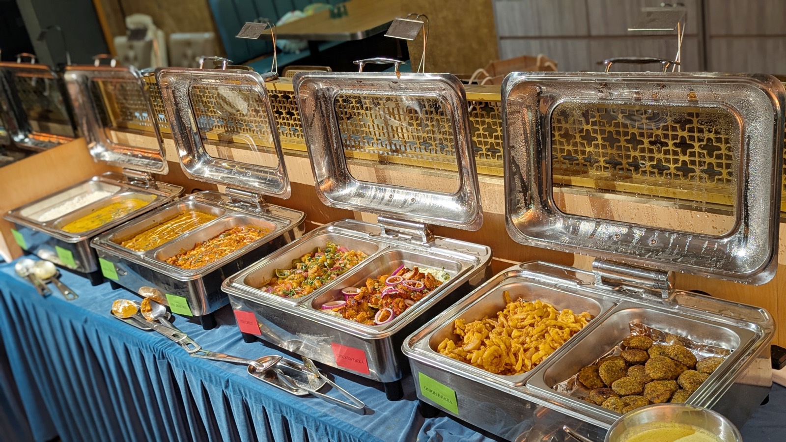 Close-up of the Woodlands buffet line with curries, tikka, onion bhajia and green kebabs